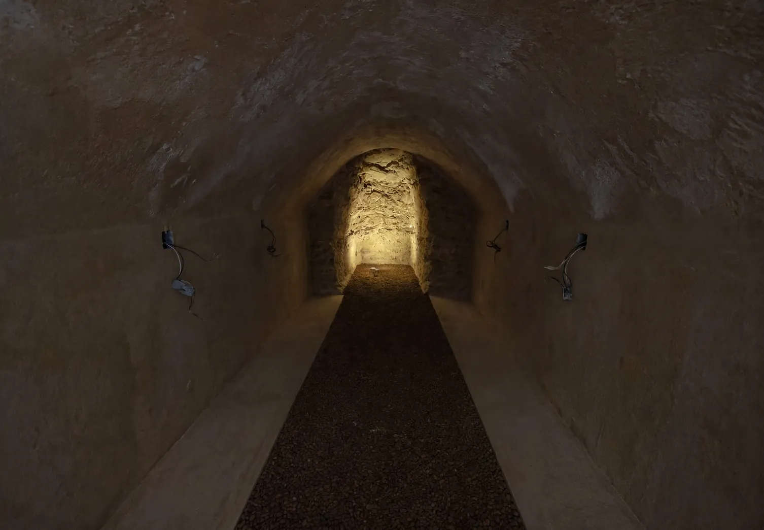 Cave voûtée en pierre avant travaux, gaines électriques en attente sur les murs